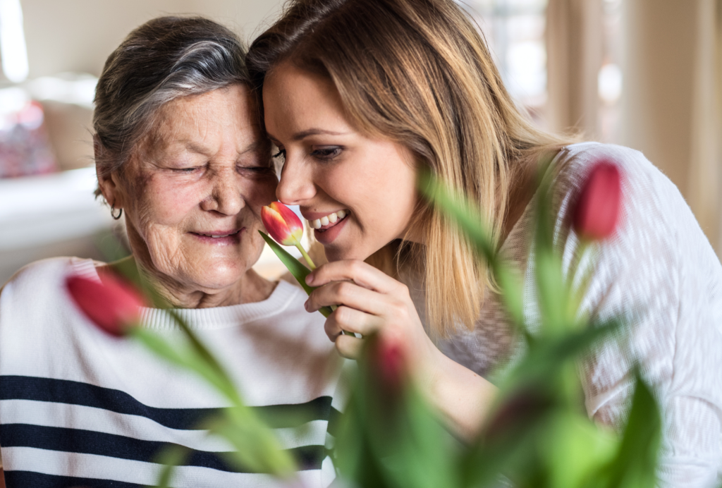 Petite fille et grand-mère avec des fleurs pour sa fête.